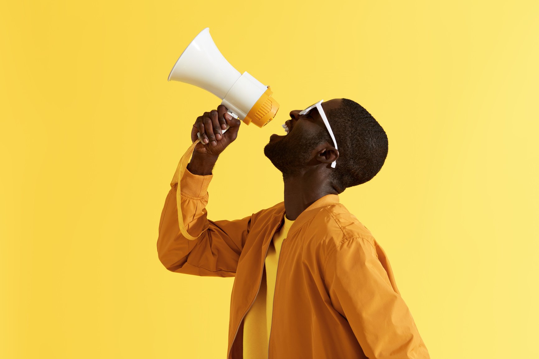 Advertising. Man screaming announcement in megaphone portrait